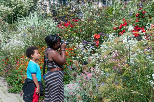 Enthusiastic visitor taking pics of the long border at Great Dixter August 2011